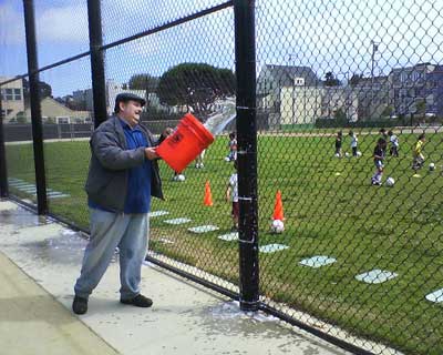 Peter rinses the soap off the fence poles Peter rinses the soap off the fence poles